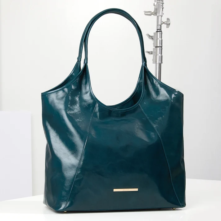 Brahmin teal designer tote bag with glossy finish, curved silhouette, double shoulder straps, contrast paneling and gold tone logo hardware.